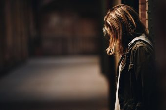 Woman looking down in a dark hallway