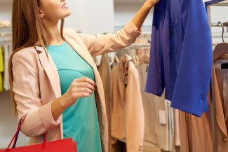Woman choosing blue jacket at store